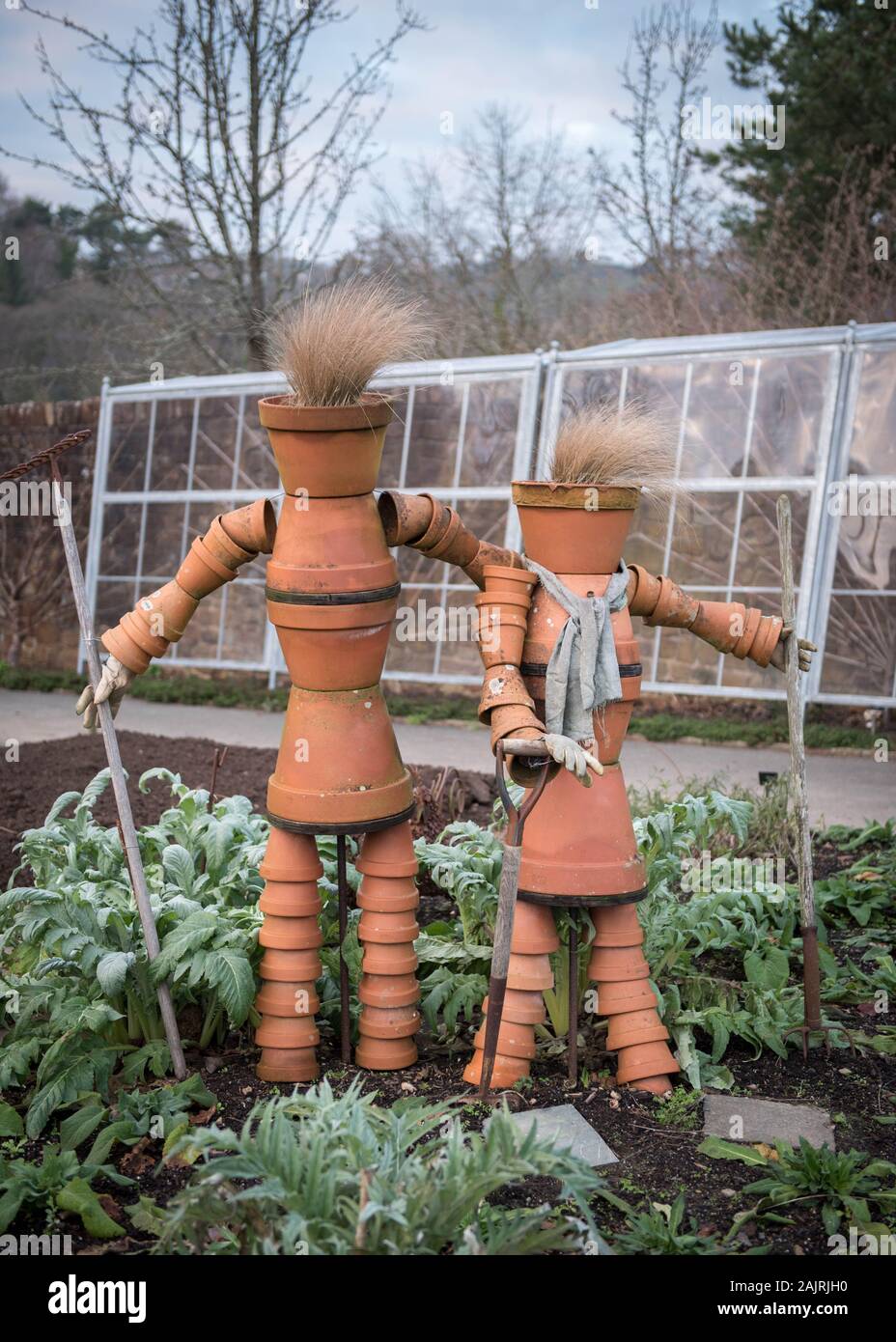 Flowerpot sculpture depicting two gardeners in the kitchen garden at RHS Rosemoor, Torrington, North Devon UK Stock Photo