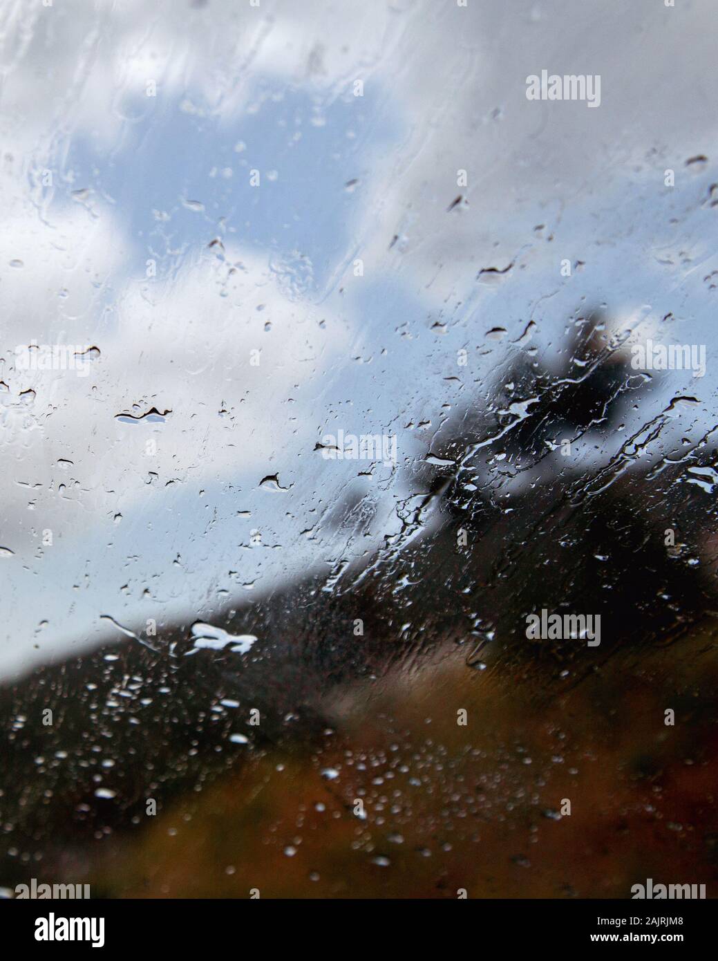 Car window with rain drops. Driving in rain. Weather background. Rainy