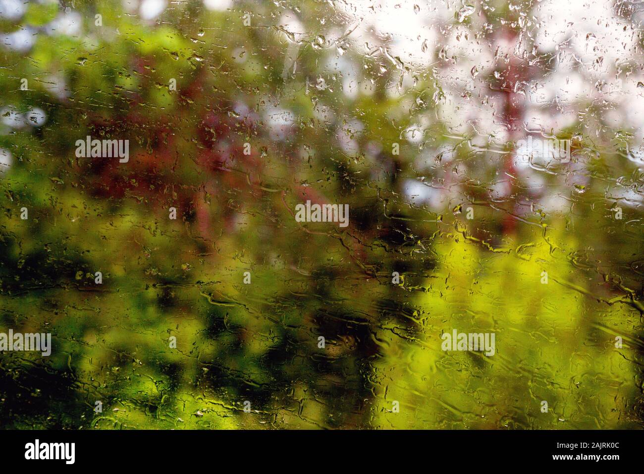 Car window with rain drops. Driving in rain. Weather background. Rainy