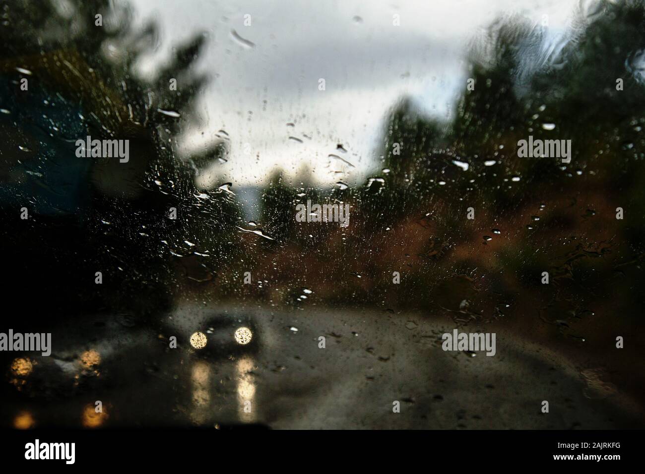 Car window with rain drops. Driving in rain. Weather background. Rainy