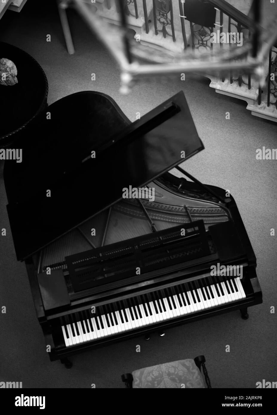 Black and White Image of Grand Piano taken from birds eye perspective at top of stairs. Stock Photo