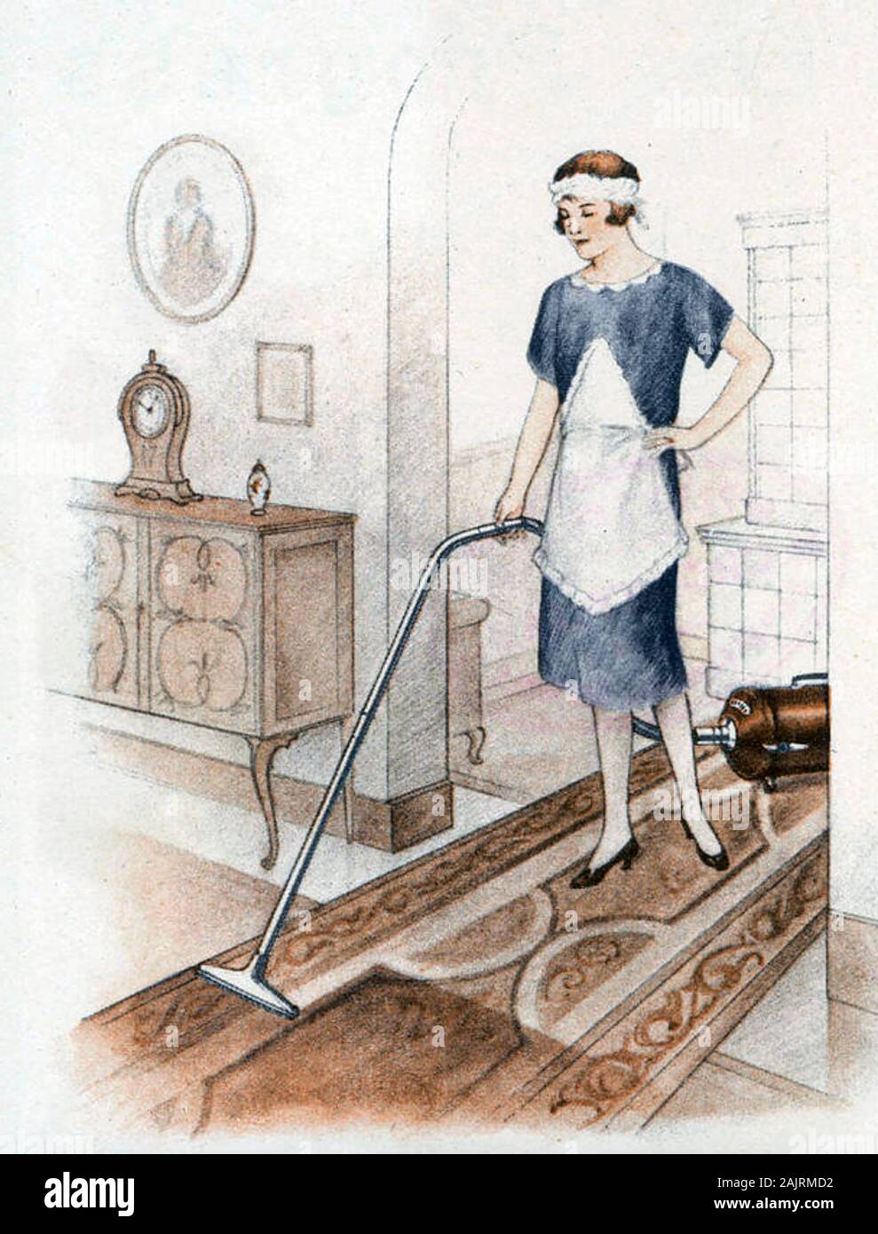 MAIDSERVANT with an early hoover about 1920 Stock Photo