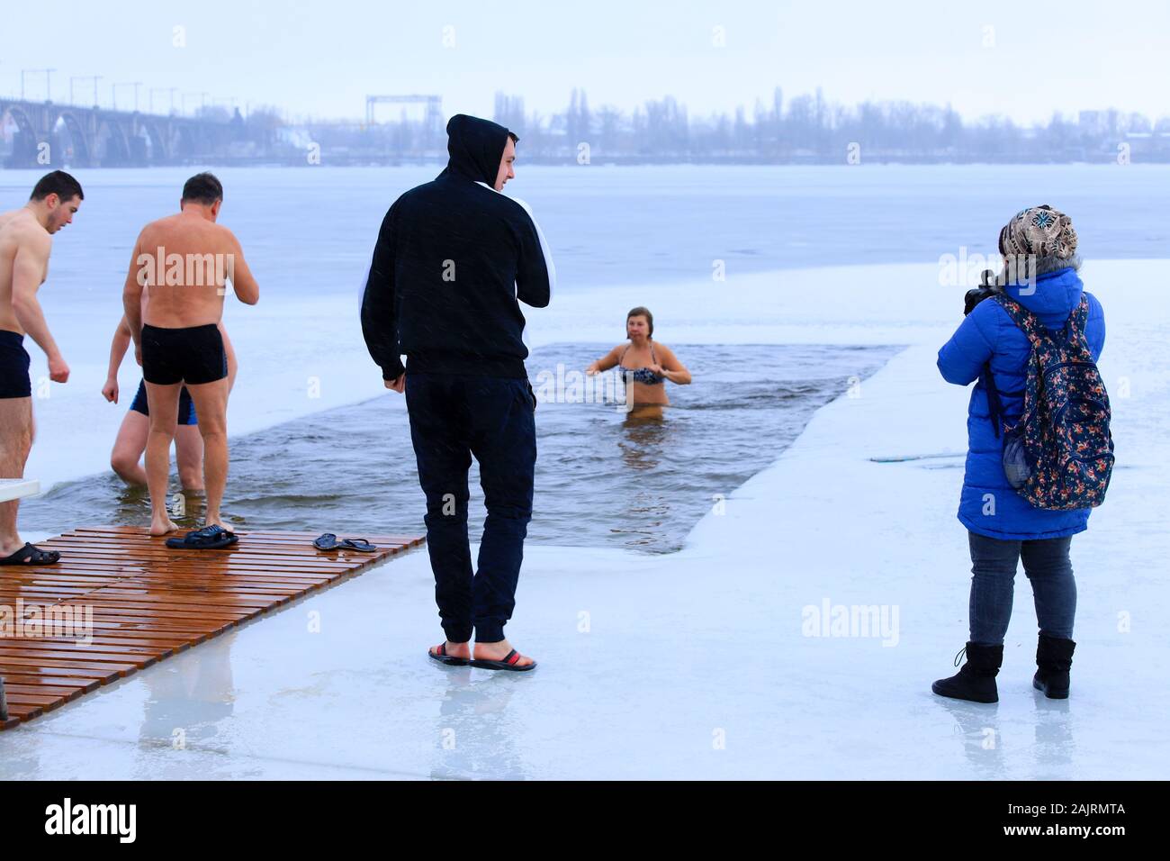 Winter sports, hardening. People stand and swim in the winter in the ice hole on the Dnieper River during the Orthodox holiday Epiphany. Dnipro city Stock Photo