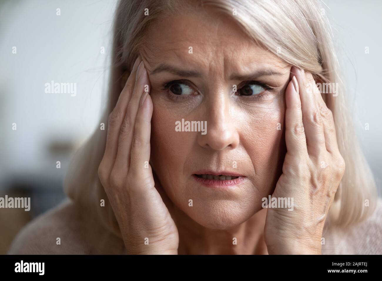 Close up of scared elderly woman having panic attack Stock Photo