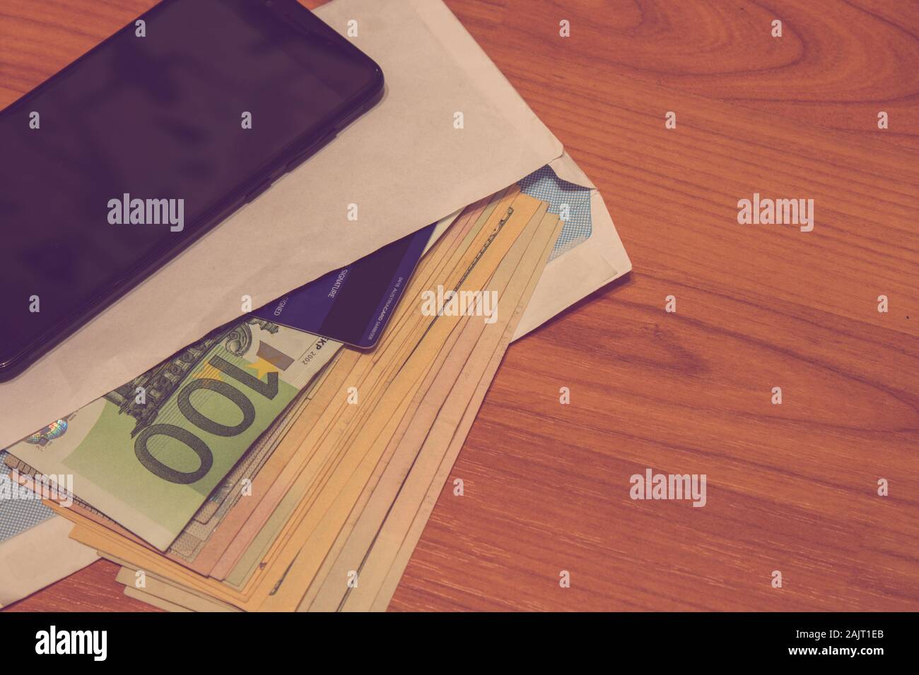 Money and credit card in a envelope on the wooden desk Stock Photo