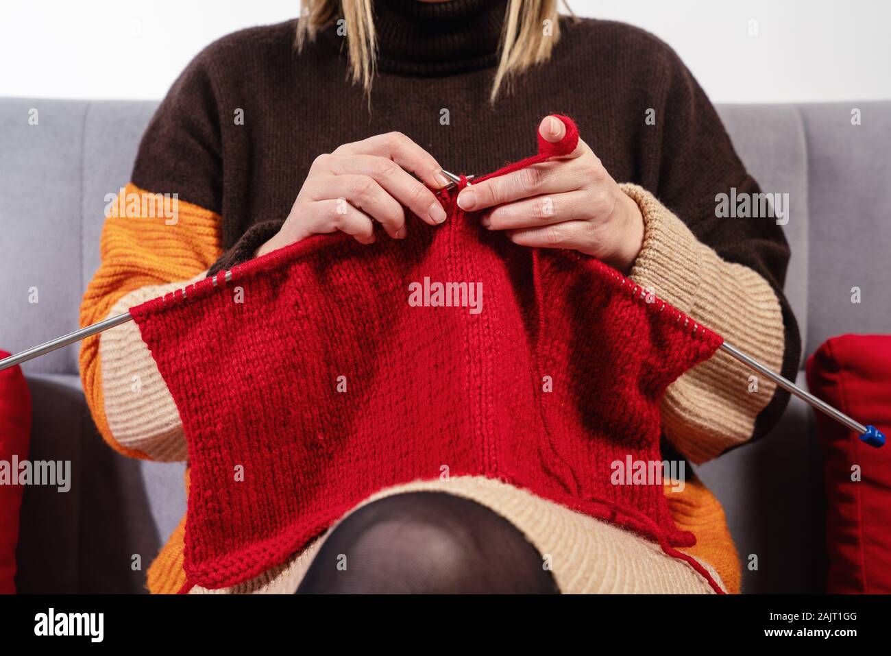 Handwork concept, young woman is knitting a needlework. Stock Photo