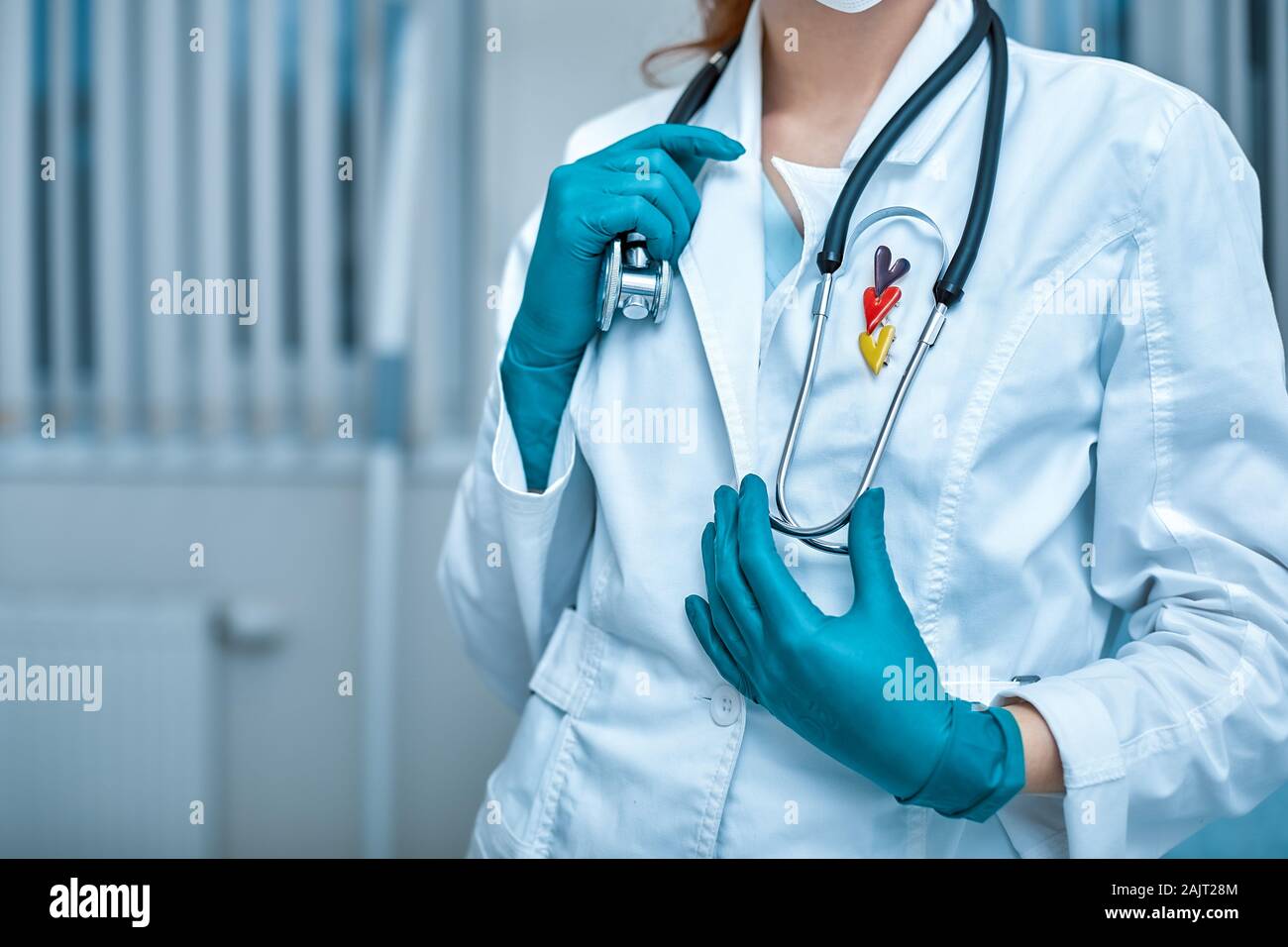 young beautiful woman doctor in white uniform and mask on her face with a  stethoscope close up on clinic background Stock Photo - Alamy