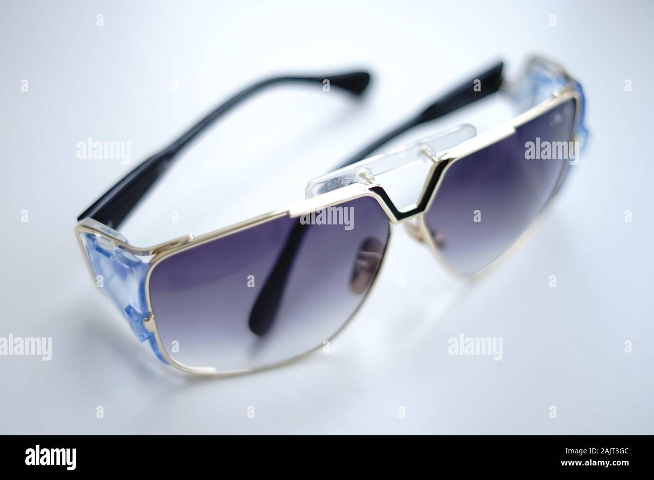 Stylish sunglasses lie on a white table Stock Photo