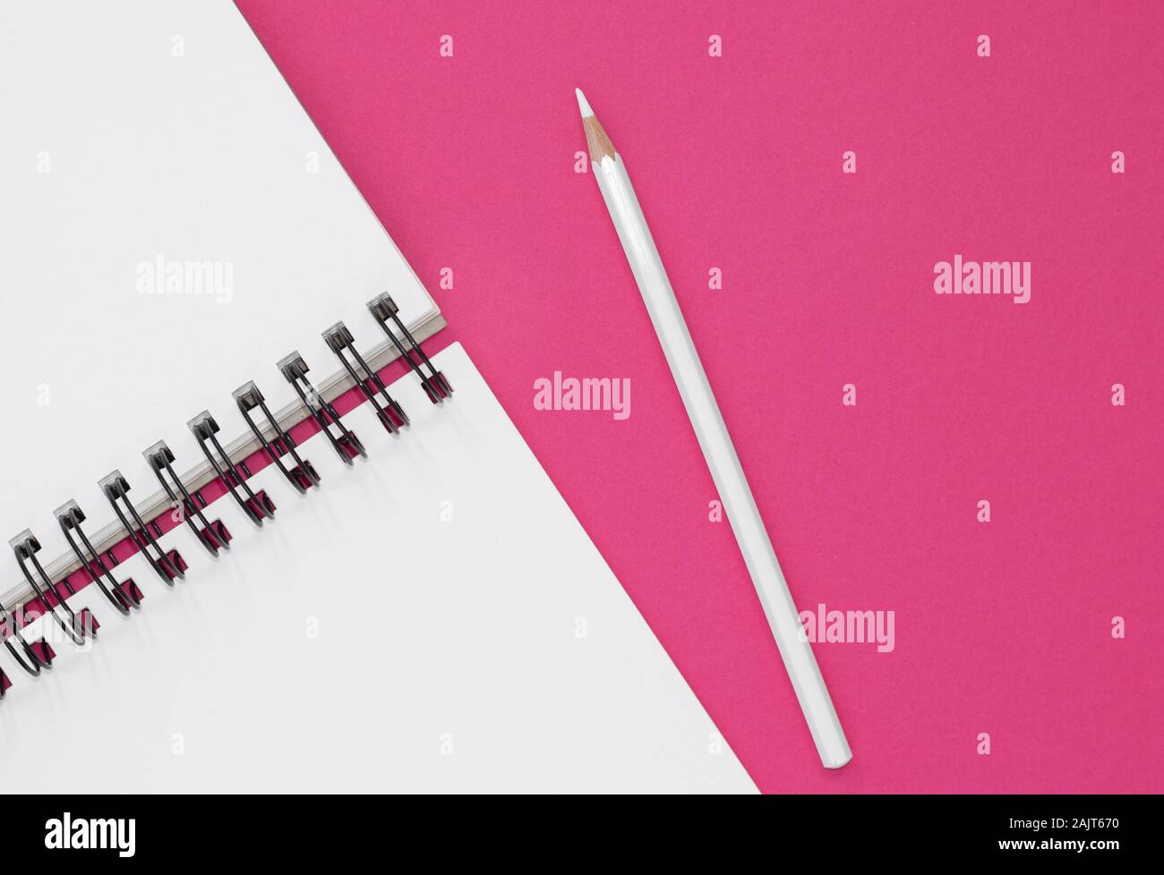 Open notepad and white pencil on a hot pink background. Top view with copy space Stock Photo