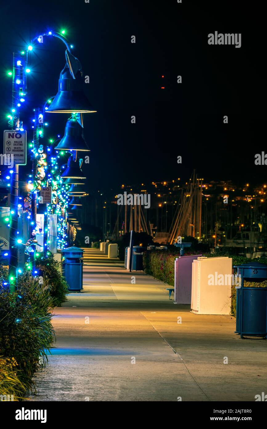 Holiday lamps decorated like candy canes along the harbor sidewalk illuminating the walking path. Stock Photo