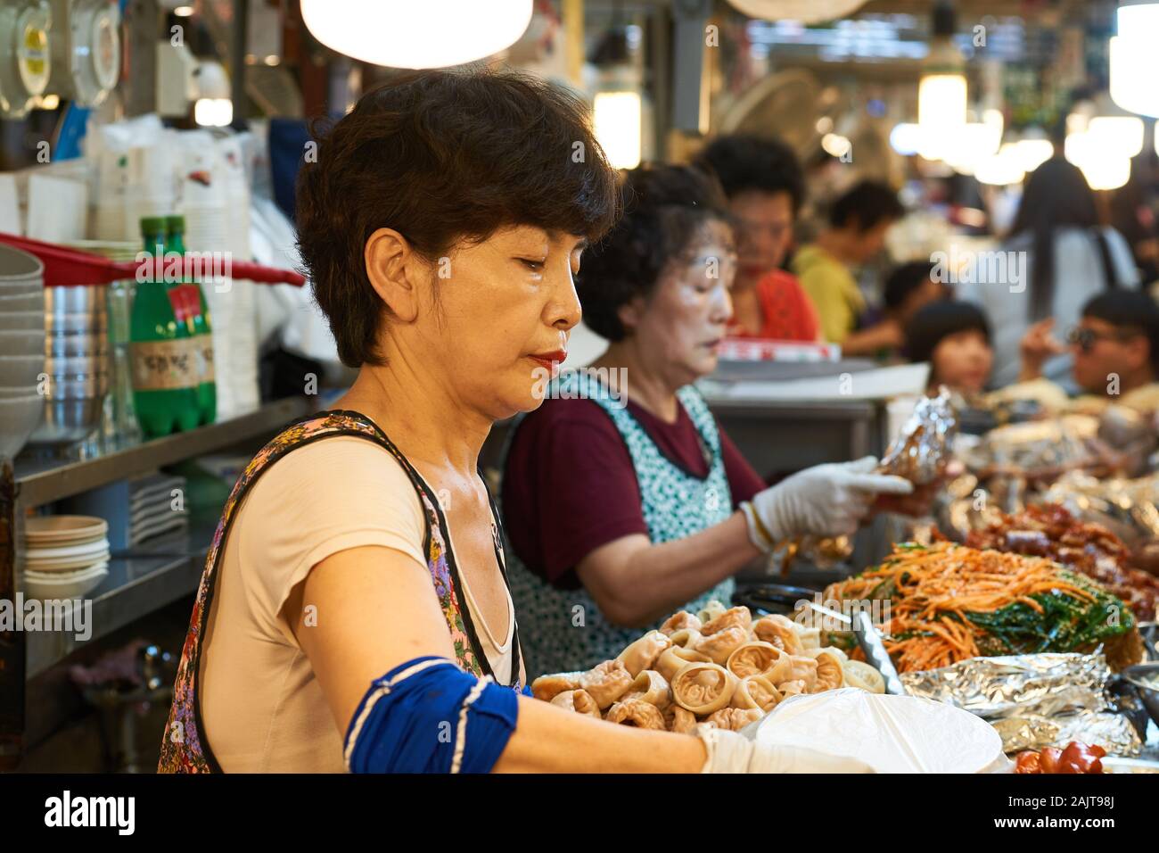 Female Korean chefs prepare traditional food for sale at Gwangjang Market in Seoul, South Korea. Stock Photo