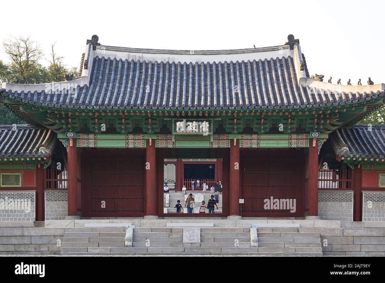 Tourists pass through Sungjeongmon gate at Gyeonghuigung (Gyeonghui Palace or Palace of Serene Harmony) in Seoul, South Korea. Stock Photo
