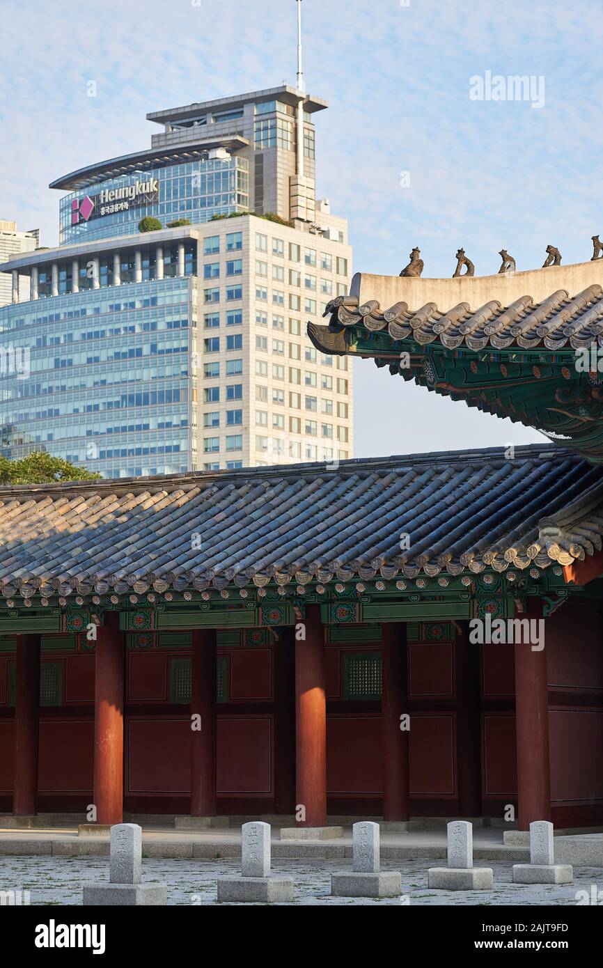 Modern Heungkuk Life Insurance building looms over traditional Heunghwamun gate at Gyeonghuigung (Gyeonghui Palace or Palace of Serene Harmony). Stock Photo