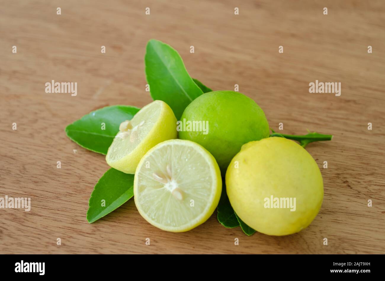Closeup Of Cut, And Whole Key Lime Along with Leaves Stock Photo