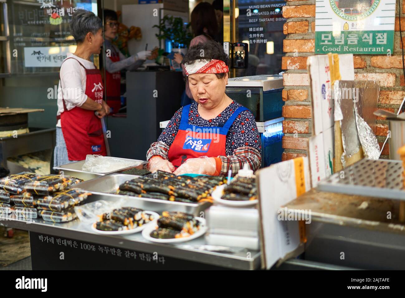 A sitting Korean woman waits for customers at her food stall at Gwangjang Market in Seoul, South Korea. Stock Photo