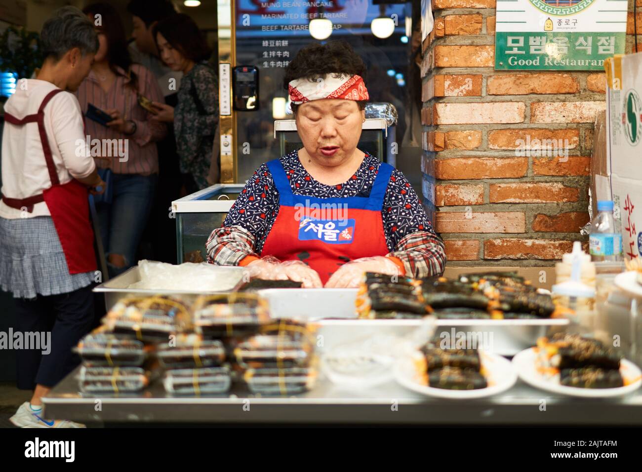 A sitting Korean woman waits for customers at her food stall at Gwangjang Market in Seoul, South Korea. Stock Photo