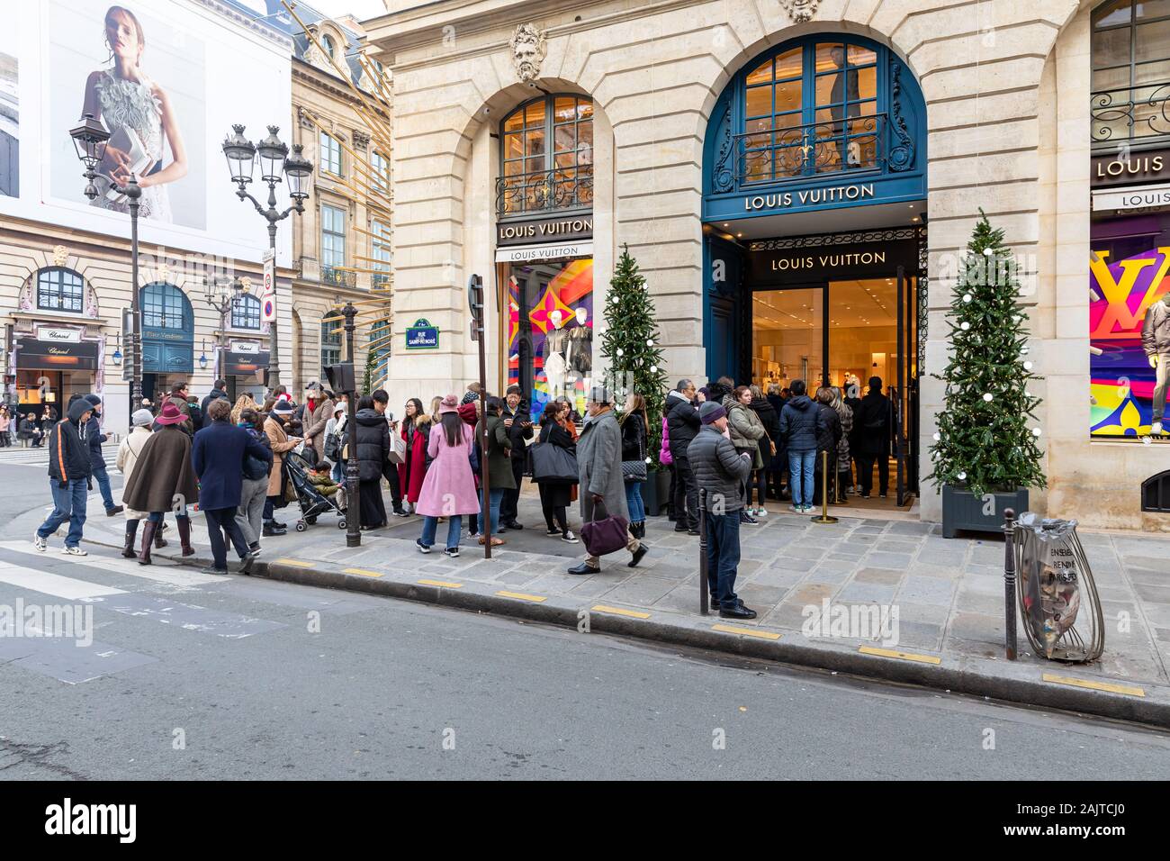 Long queue outside Louis Vuitton Maison Vendôme, Christmas trees by the entrance; Place Vendôme, Paris, France Stock Photo