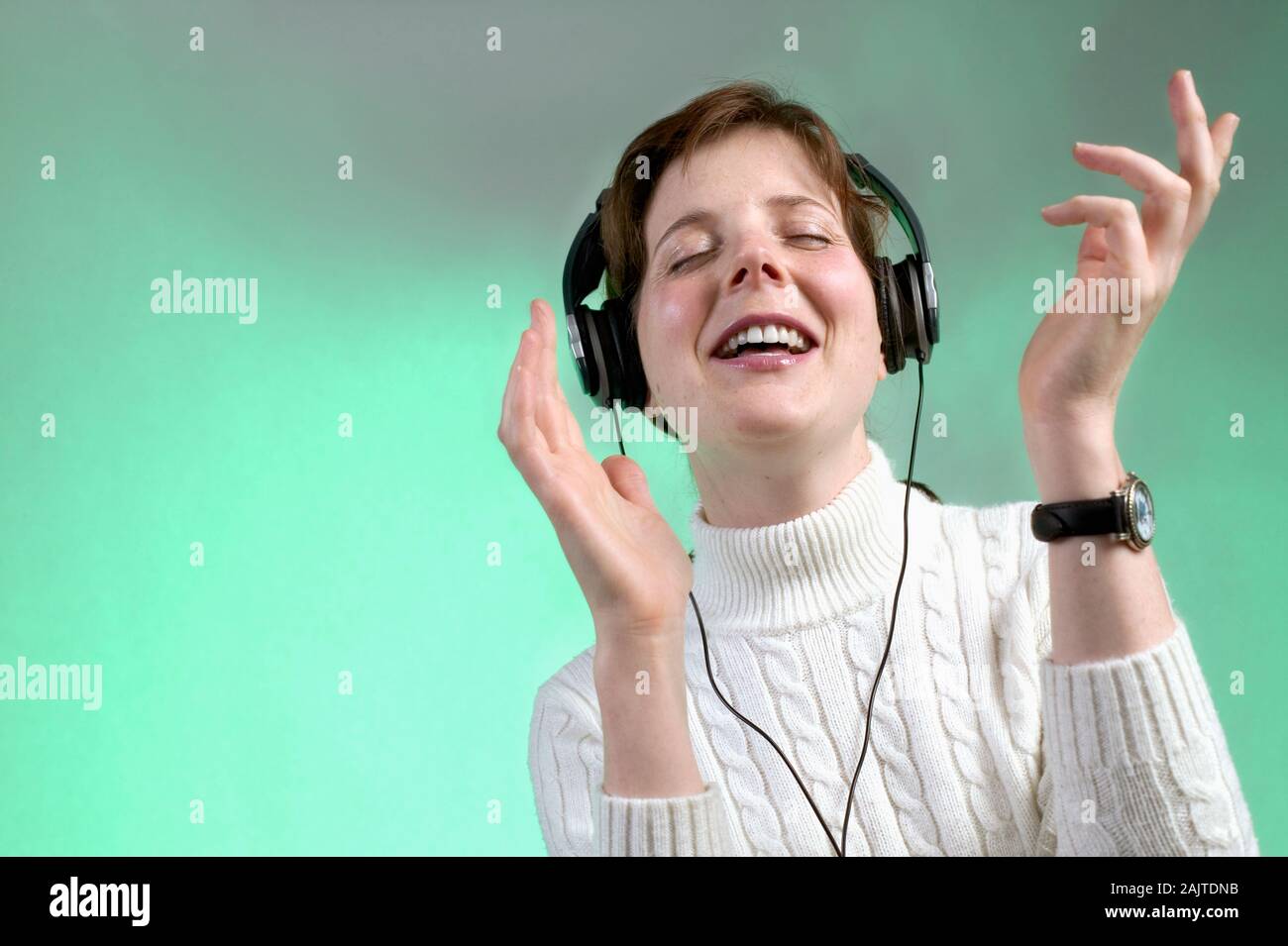 Caucasian Woman Listening To Music On Headphones Stock Photo