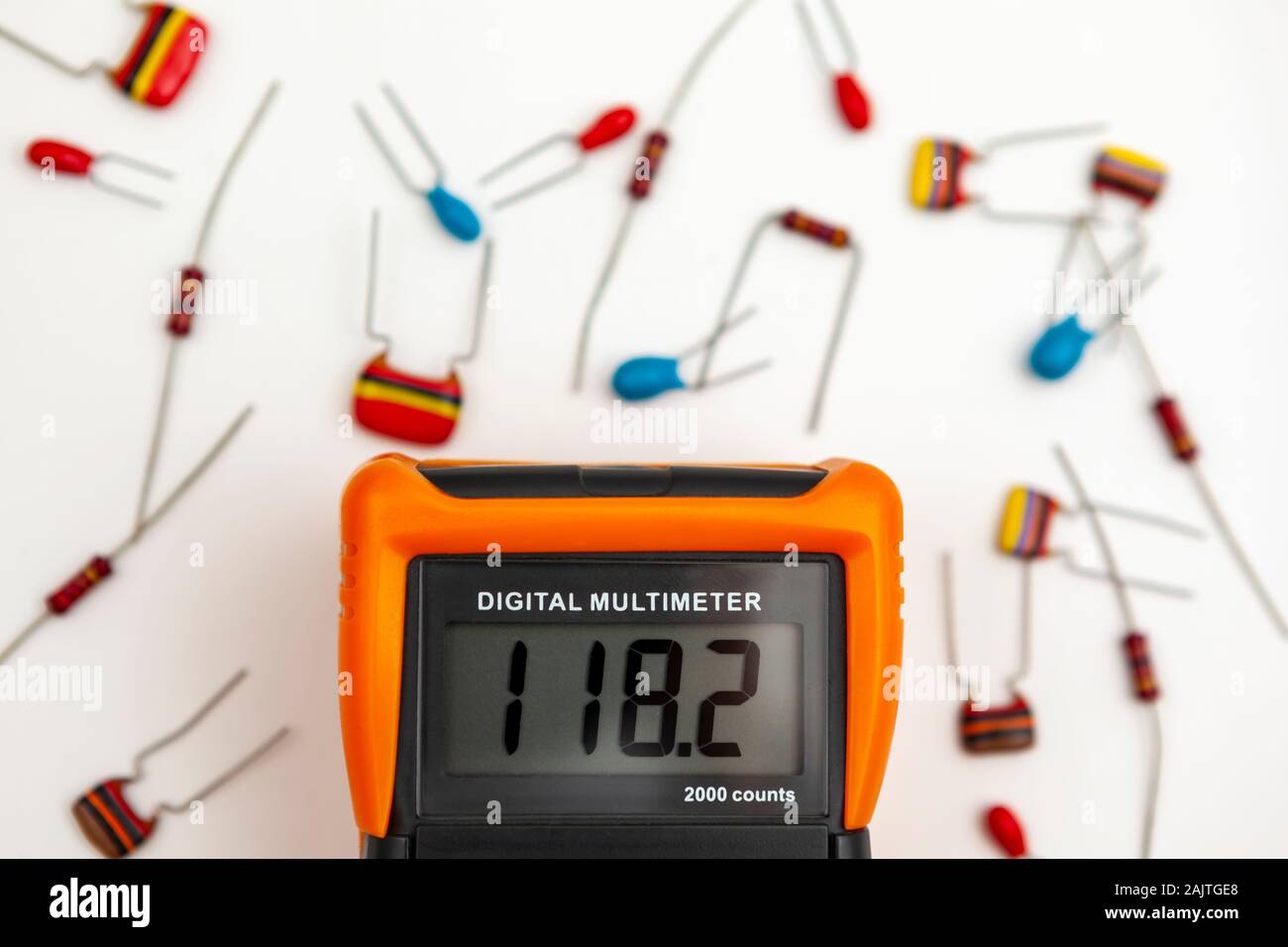 Digital multimeter showing a voltage reading surrounded by electronic