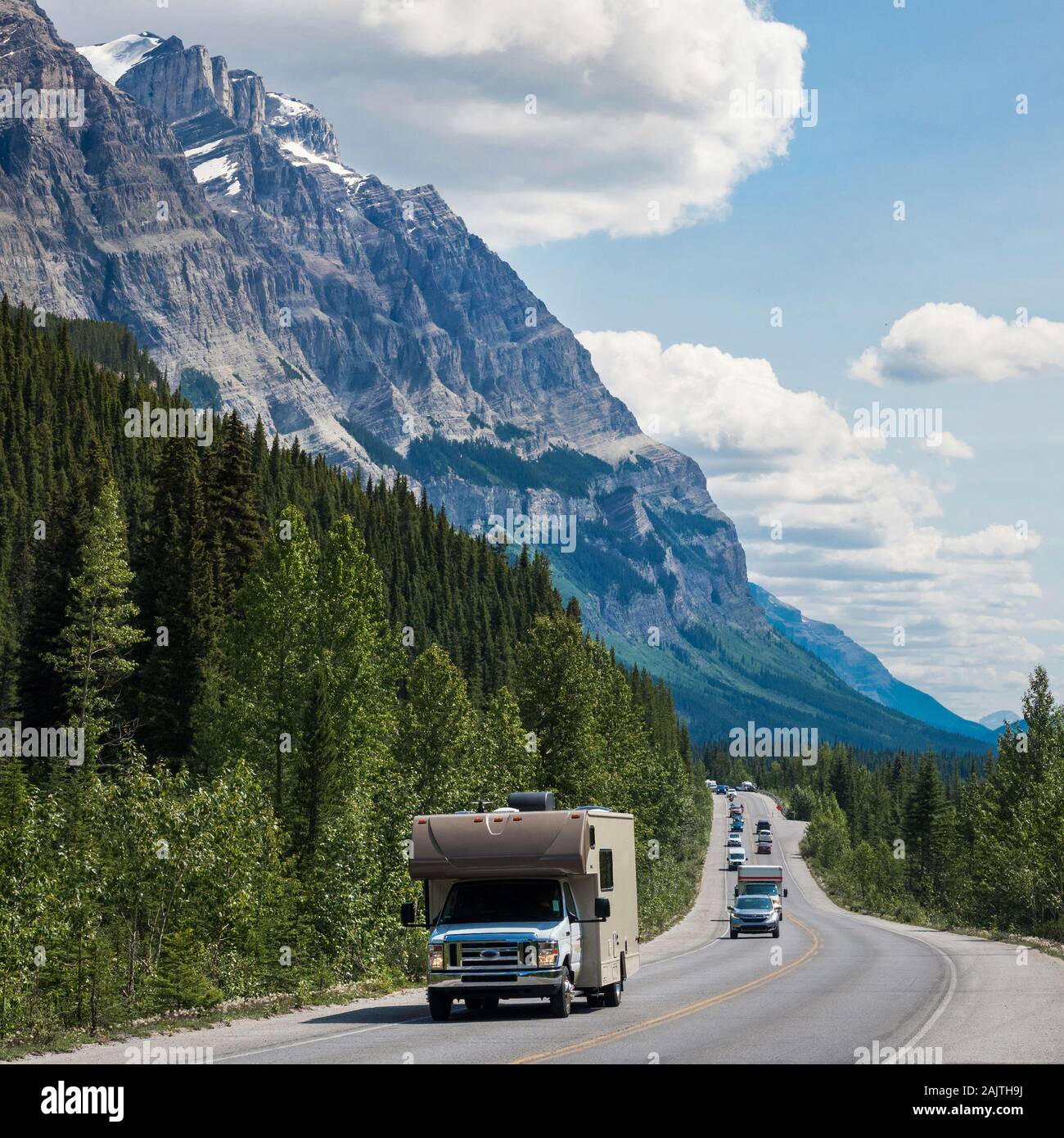 Vehicles driving down the iconic Icefields Parkway route between Banff and Jasper National Parks in Alberta, Canada. Stock Photo