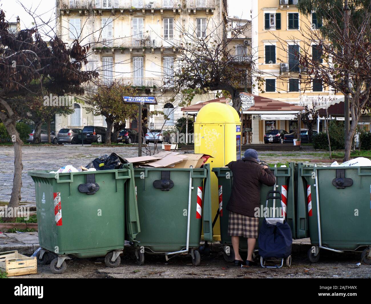 Old lady looking for scraps from refuse bins in Corfu, Greece Stock