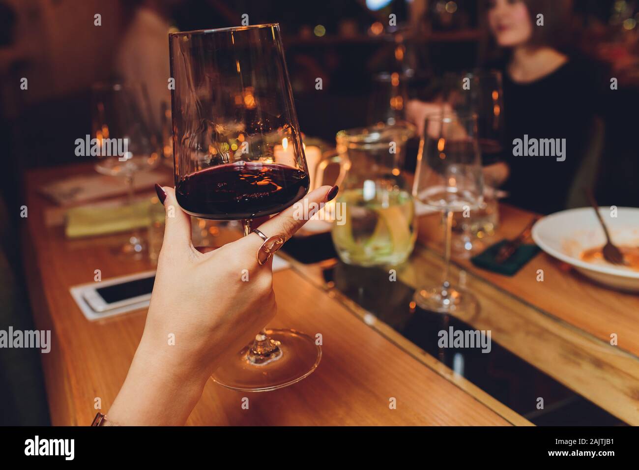 female hand holding glass of red wine Stock Photo - Alamy