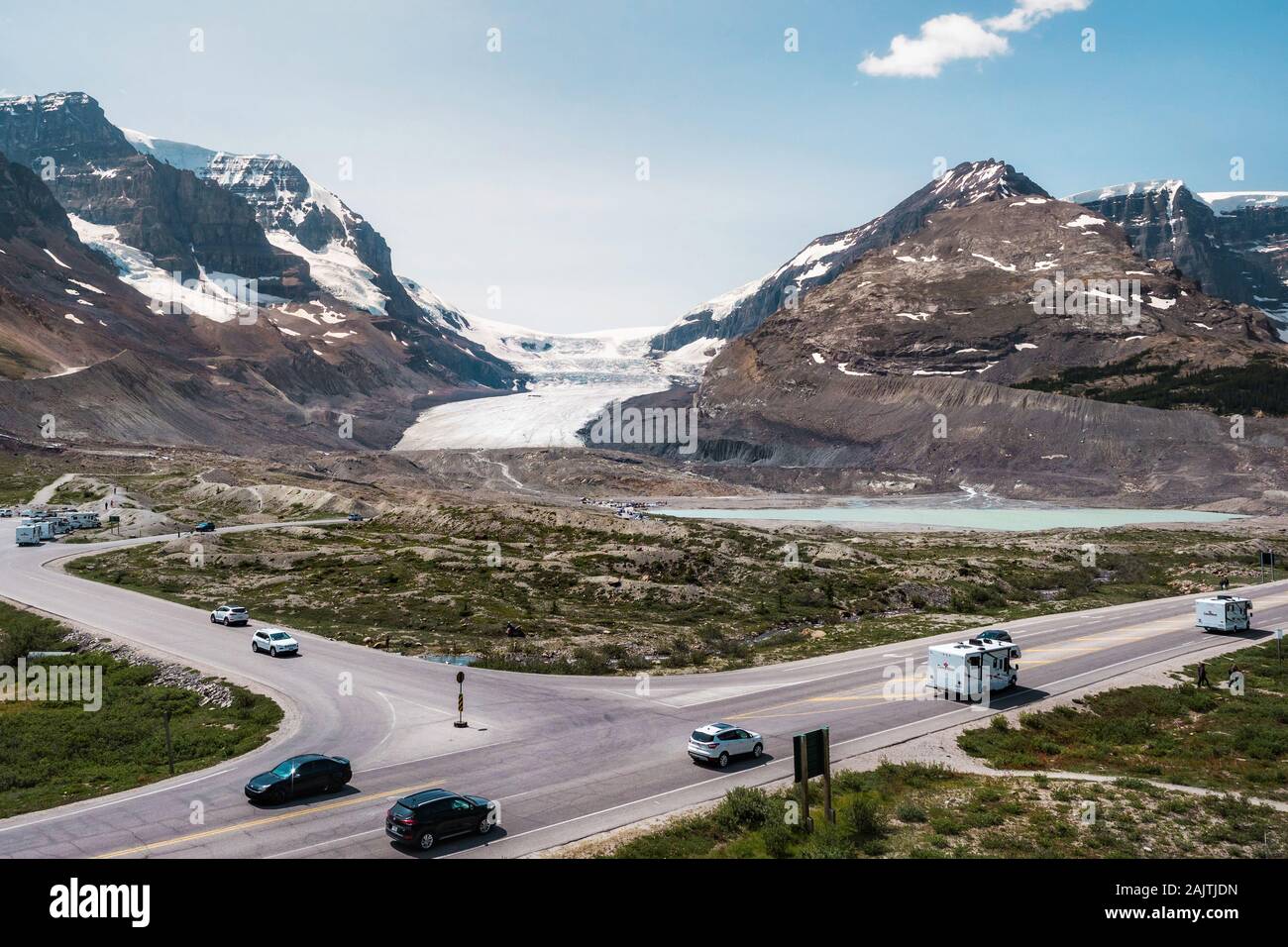 View of Athabasca Glacier with vehicles driving by on the famous Icefields Parkway route between Jasper and Banff National Parks in Alberta, Canada. Stock Photo