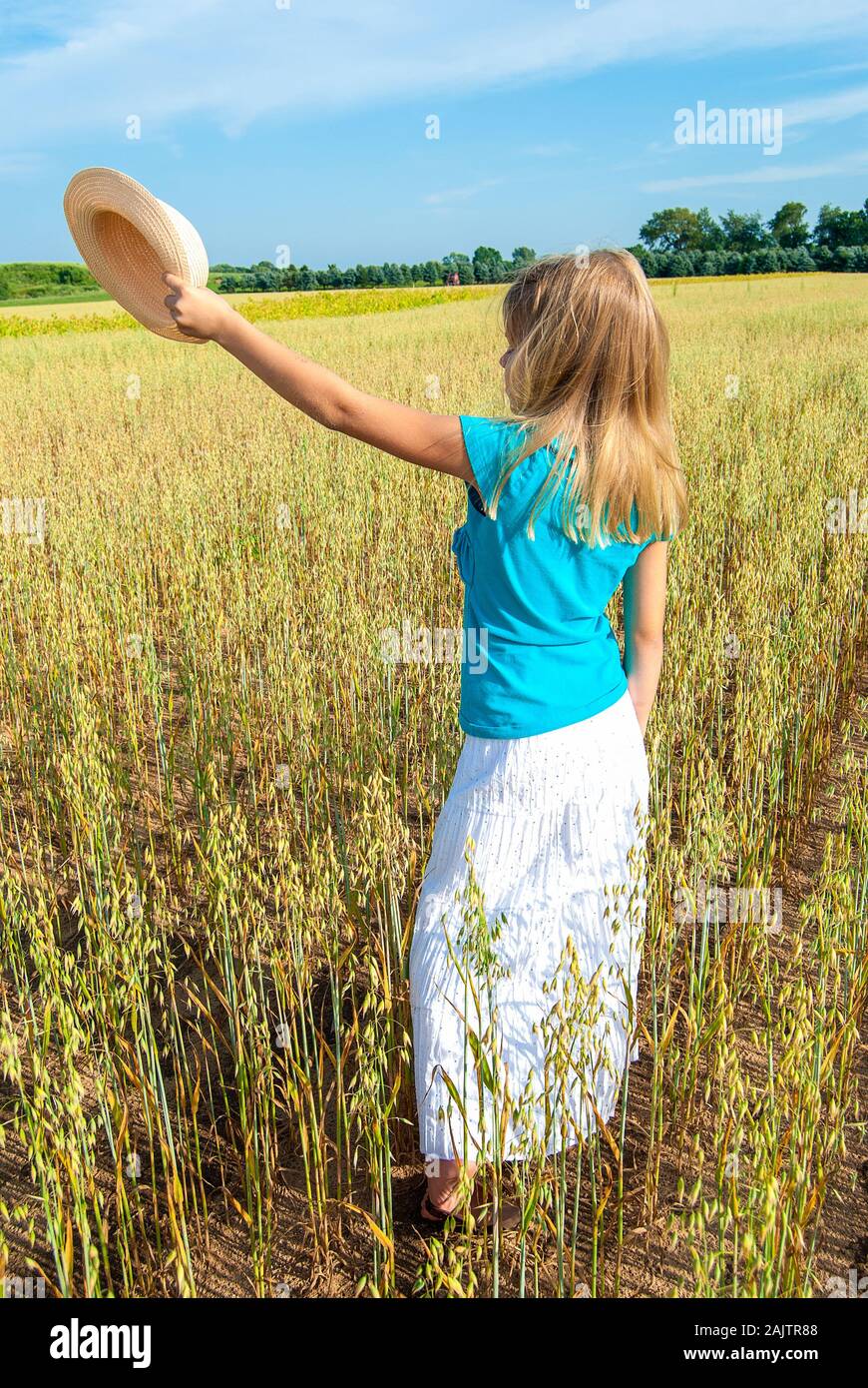 Caucasian young blond girl with hat in Michigan wheat field Stock Photo