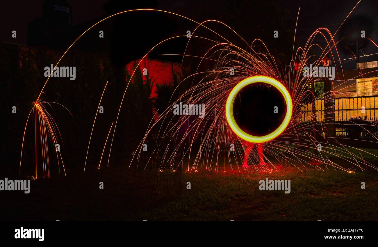 a long exposure photography of an steel wool on fire going in circles and dropping iron on fire