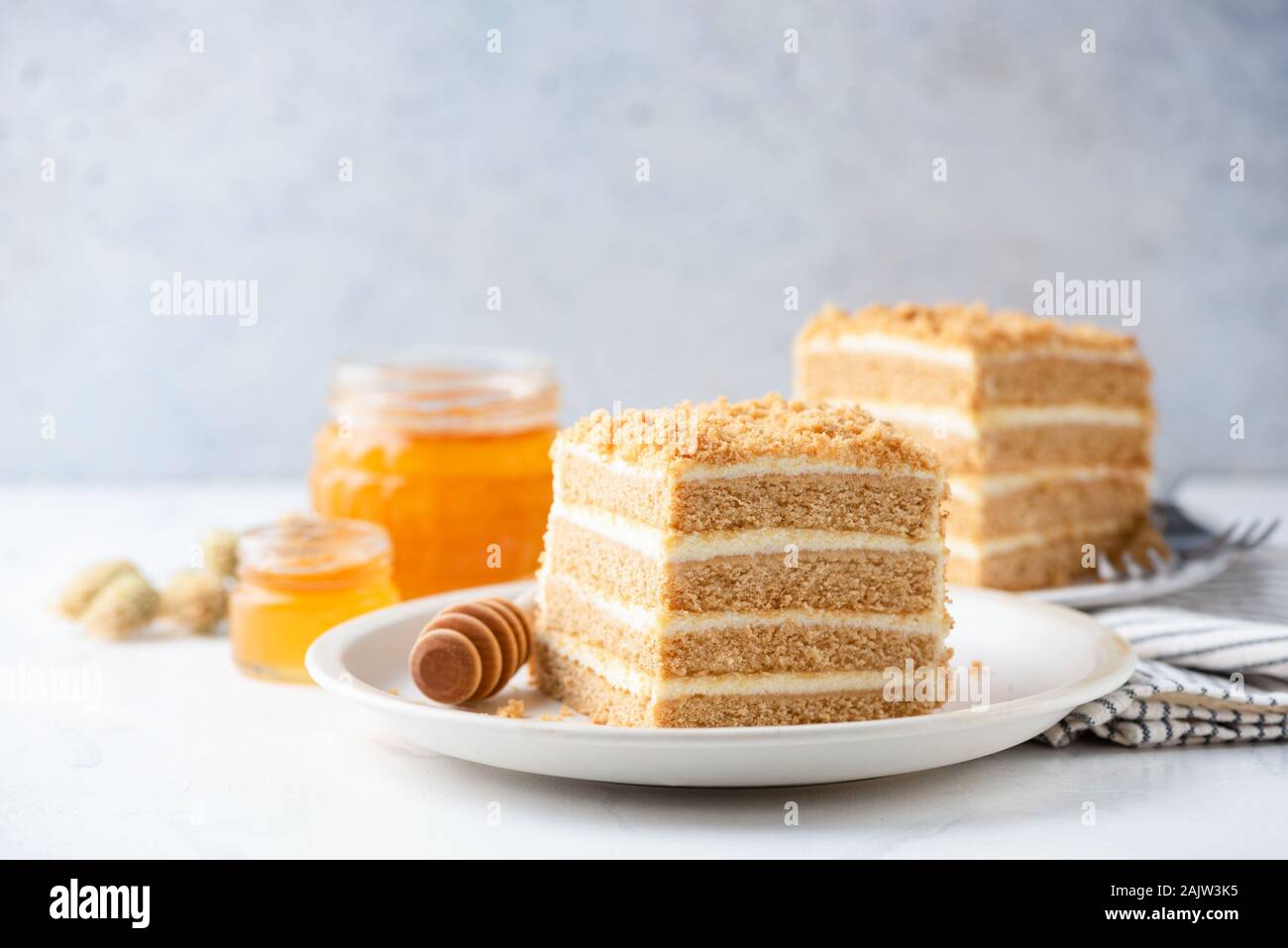 Slice of layered honey cake Medovik on a white plate with copy space for text, horizontal orientation Stock Photo