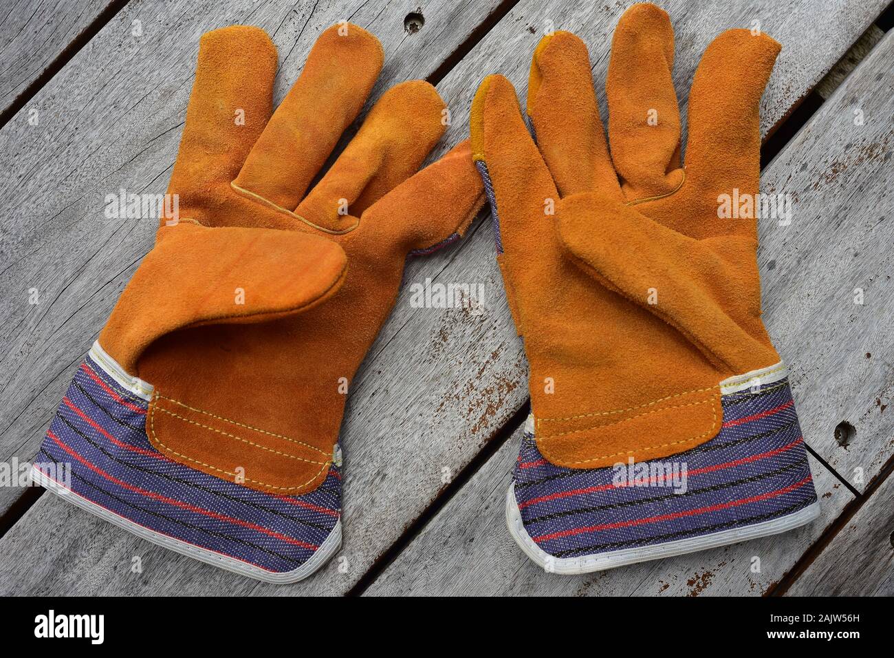 Pair of work gloves made from cheap leather with textile extensions