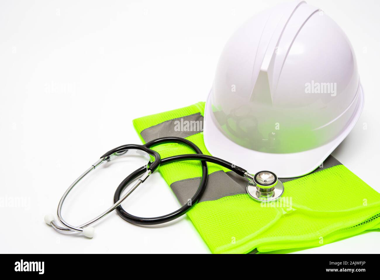 On a white background, there are safety hats, work clothes, and stethoscopes. Stock Photo