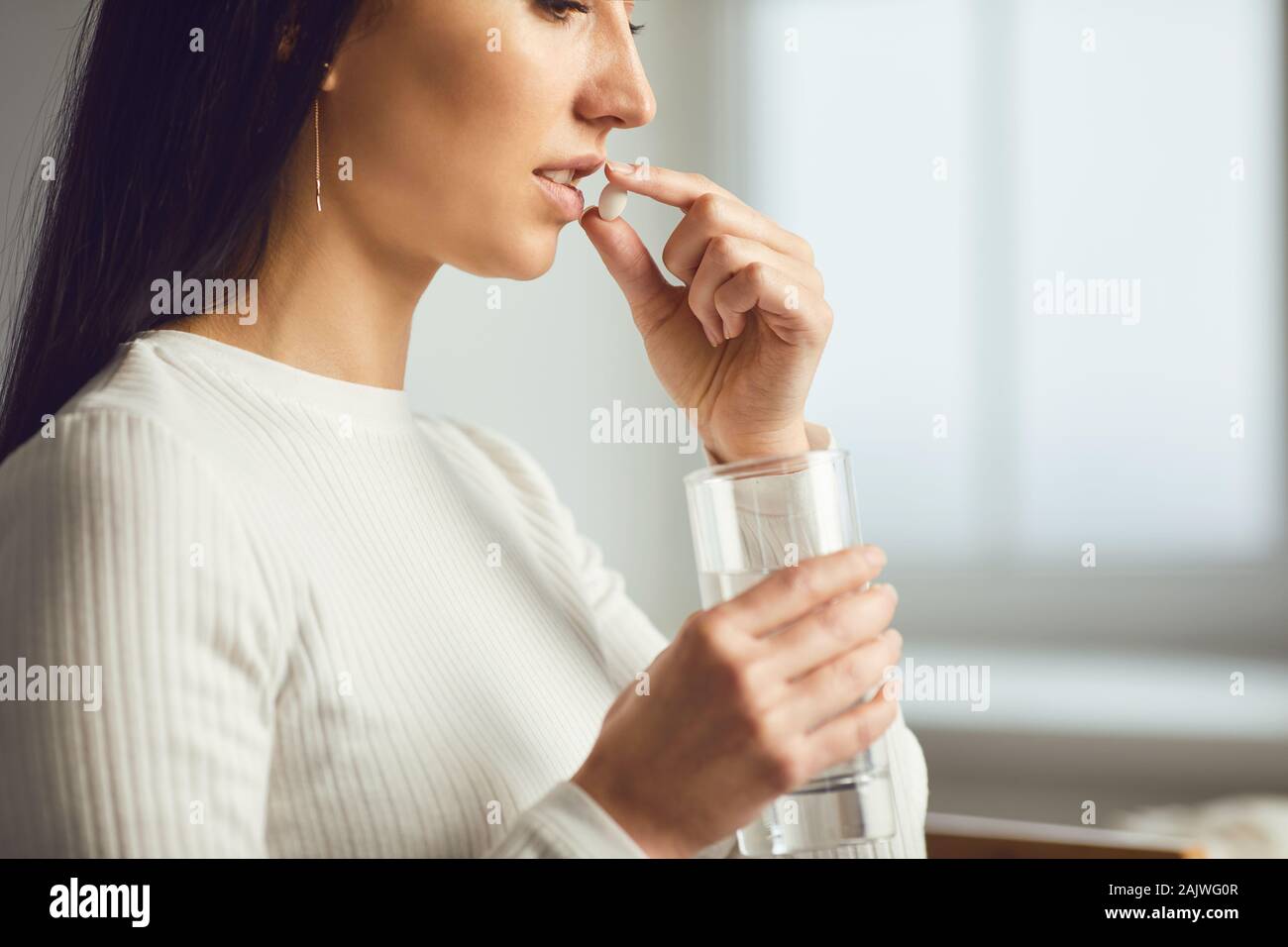 Pills tablet in hand of the girl in the room. Concept virus cold pill sick flu sickness headache flu illness Stock Photo