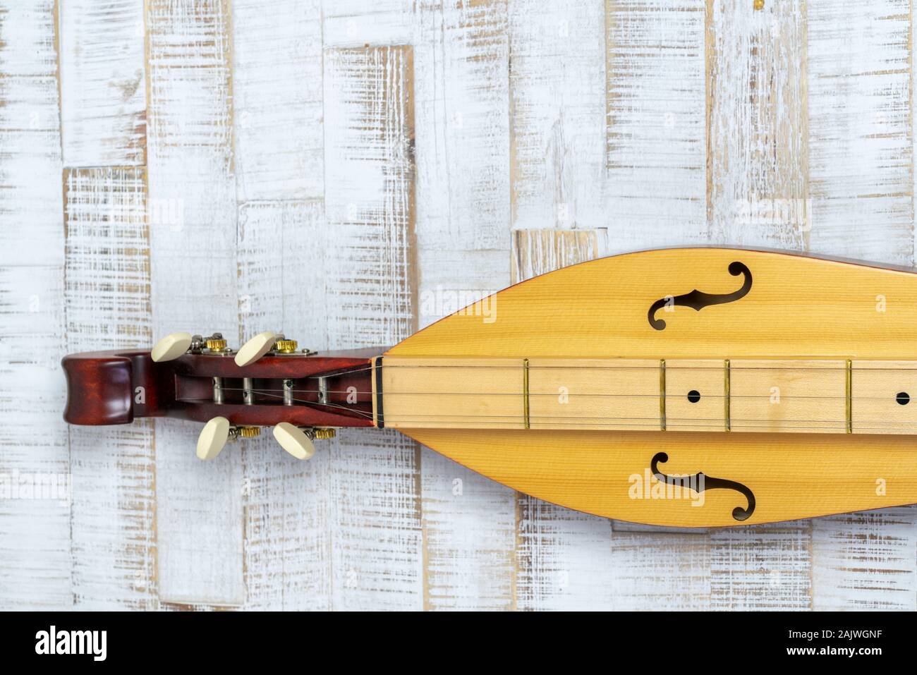 Detail view of an Appalachian mountain dulcimer musical instrument on a rustic white wooden background Stock Photo