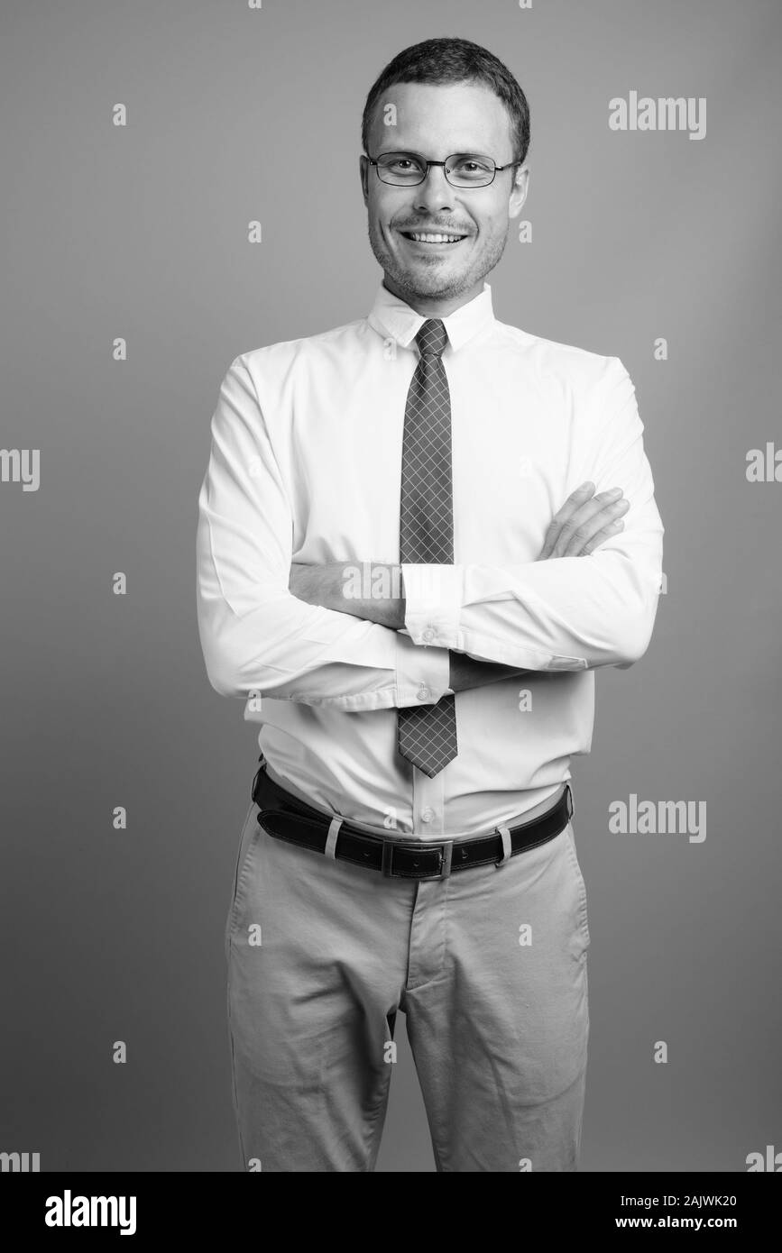 Portrait of handsome businessman against gray background Stock Photo ...