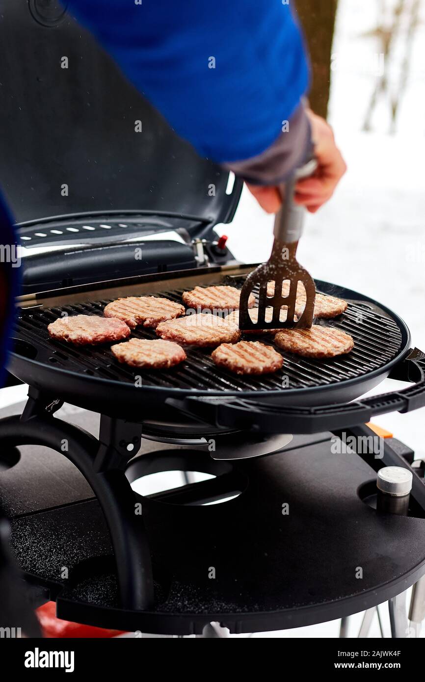 Man grilling steaks on a portable BBQ, Snowy winter barbecue Stock Photo -  Alamy