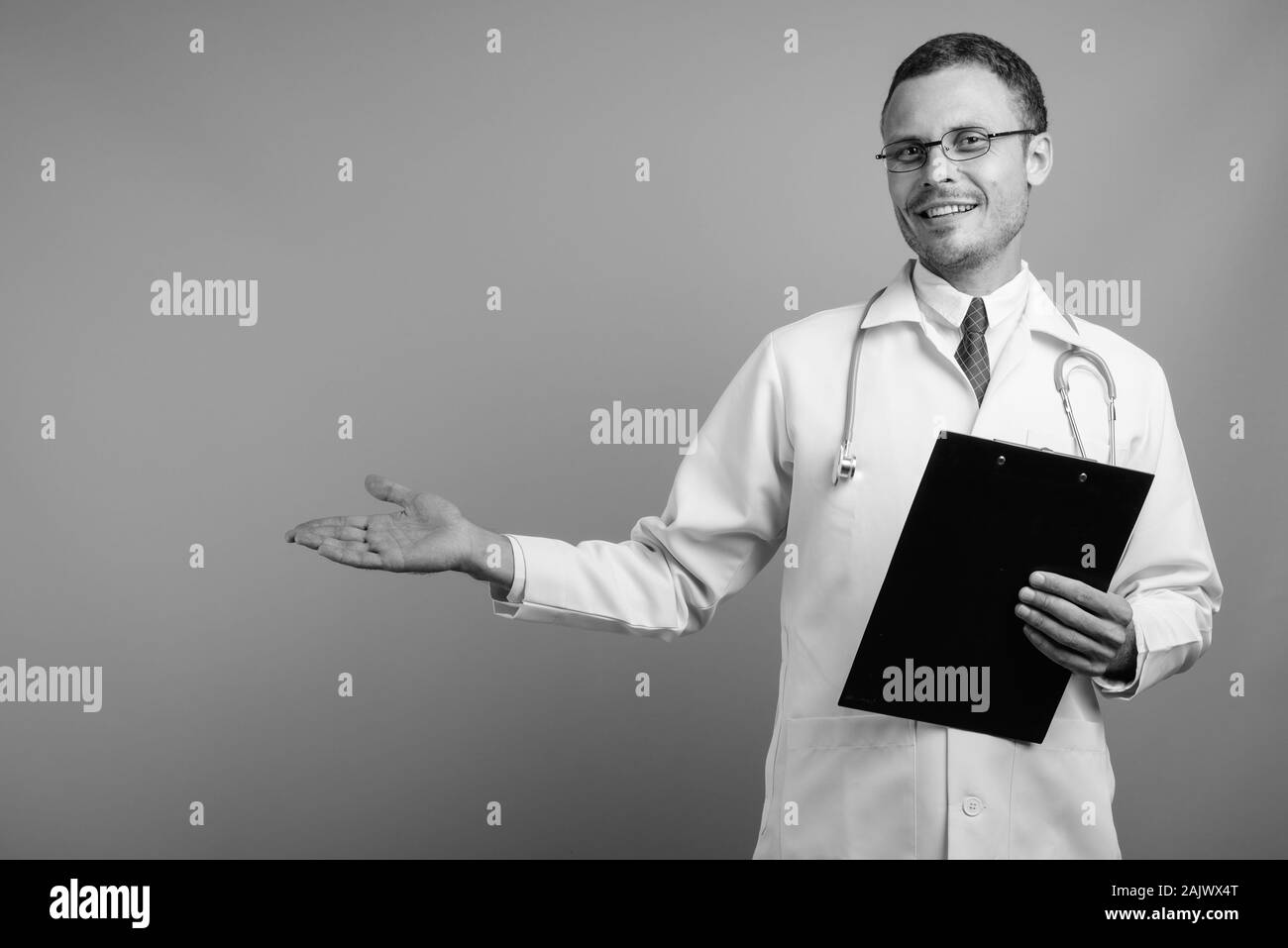 Doctor smiling holding clipboard Black and White Stock Photos & Images ...