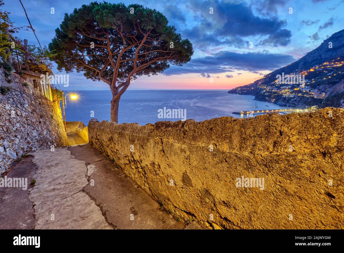 Small alleyway with a pine tree in Amalfi, Italy, at sunset Stock Photo