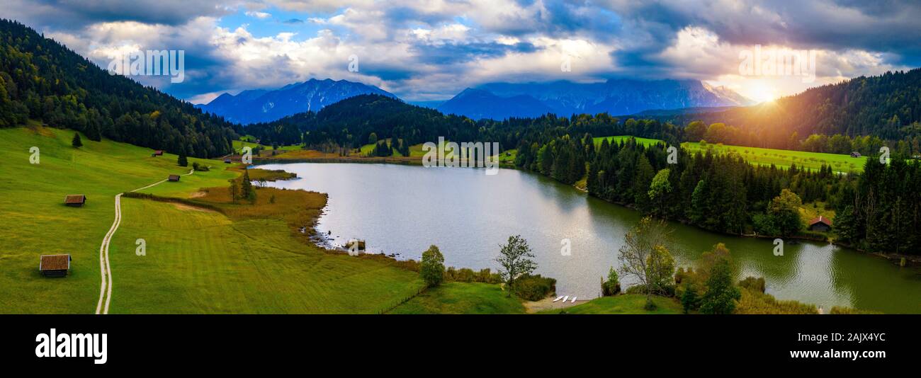 View from flying drone. Astonishing evening view of Wagenbruchsee (Geroldsee) lake with Westliche Karwendelspitze mountain range on background, Bavari Stock Photo