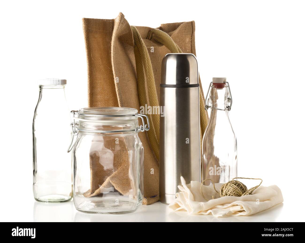 Zero waste or waste free shopping utensils with burlap bag, glass bottles and cotton bag over white background - waste reduction eco lifestyle or bulk Stock Photo