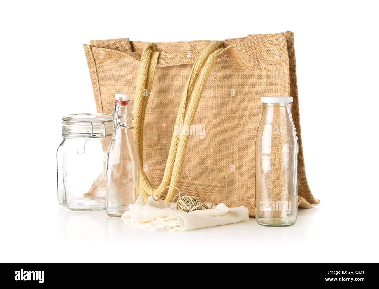 Zero waste or waste free shopping utensils with burlap bag, glass bottles and cotton bag over white background - waste reduction eco lifestyle or bulk Stock Photo