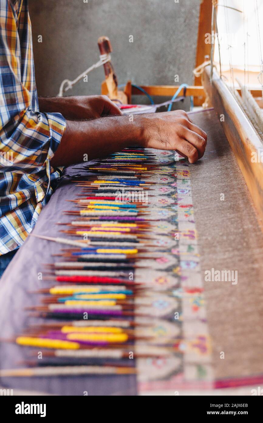 Hand weaving a colorful kashmiri pashmina shawl with light source