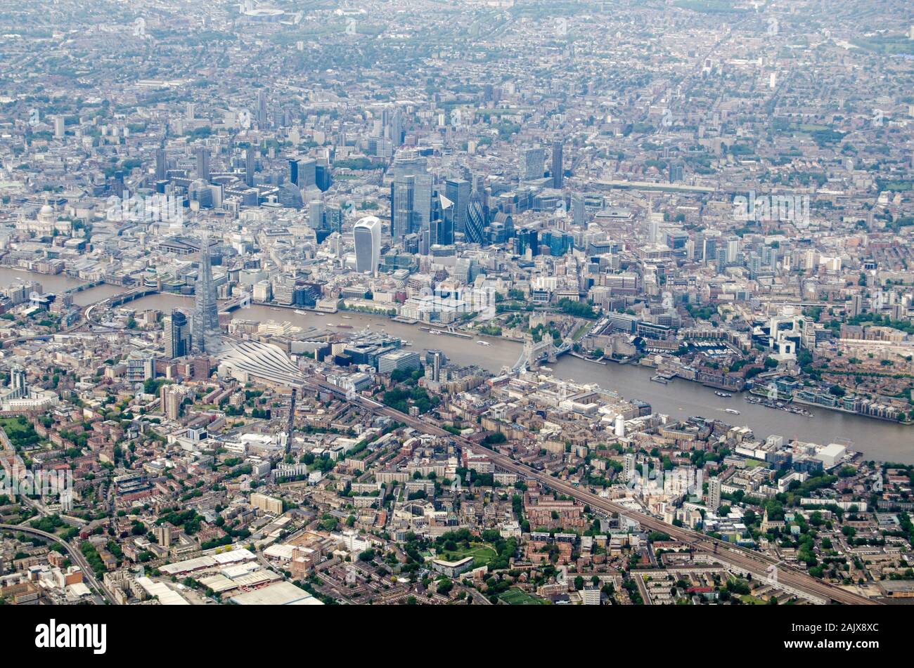 Aerial view of Southwark and the City of London with the River Thames flowing under Tower Bridge and the tower blocks of the Shard, Gherkin and the Ba Stock Photo
