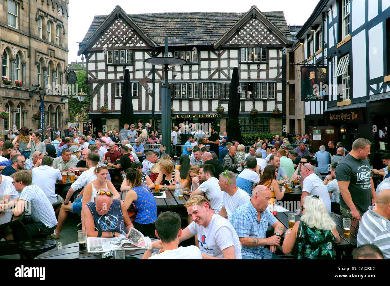 Old Wellington Inn & Sinclair's Oyster Bar, busy with people drinking in beer garden outdoors, Manchester, England, UK, Europe Stock Photo