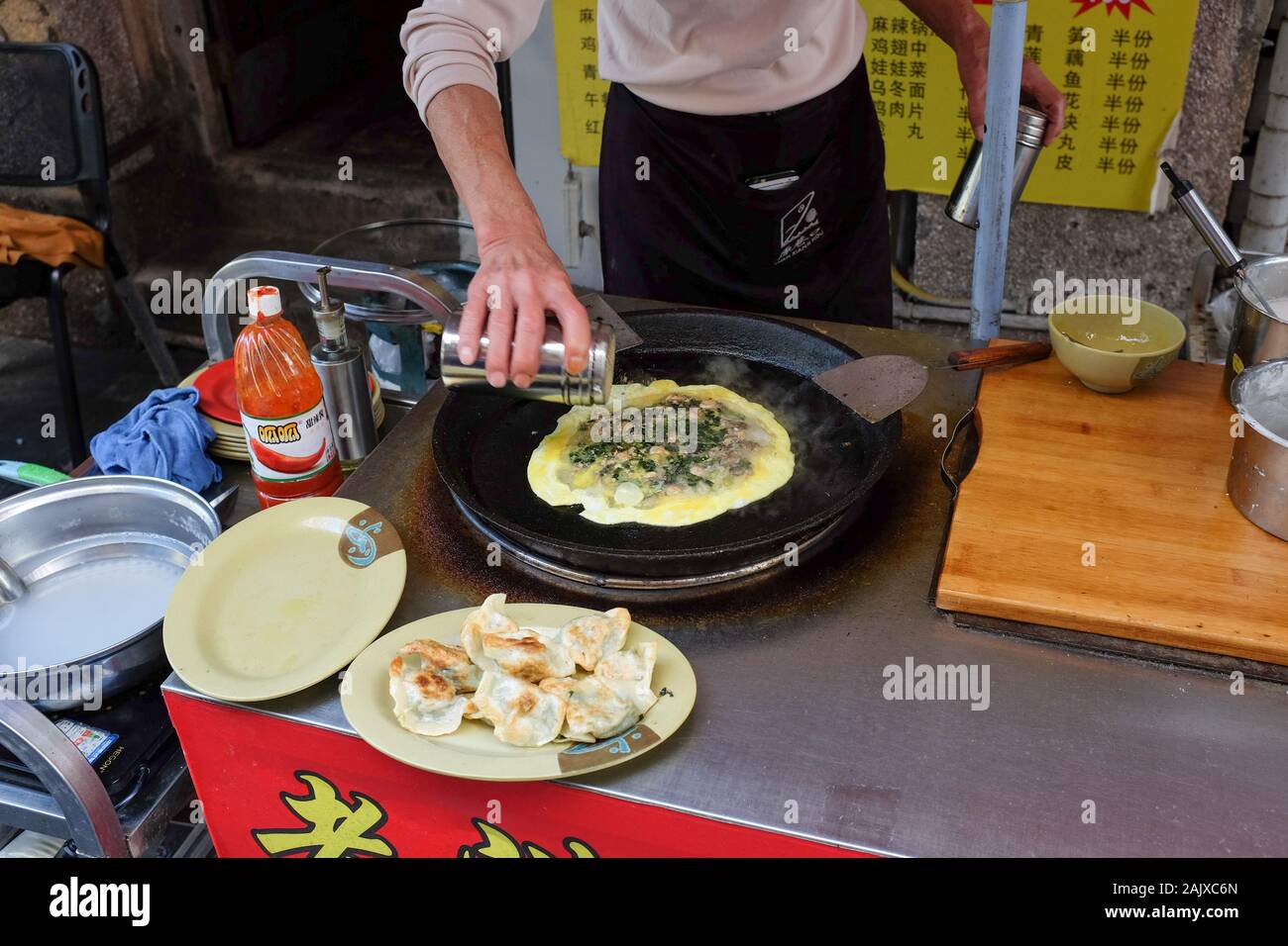 A man cooks food at a street stall on the island of Gulangyu in Xiamen (Amoy), China. Stock Photo