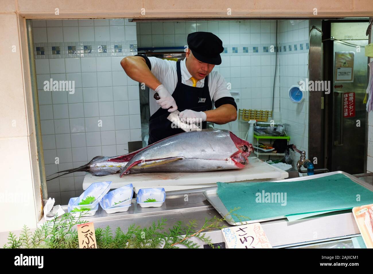 A man prepares a tuna fish for sale at Daimaru department store in