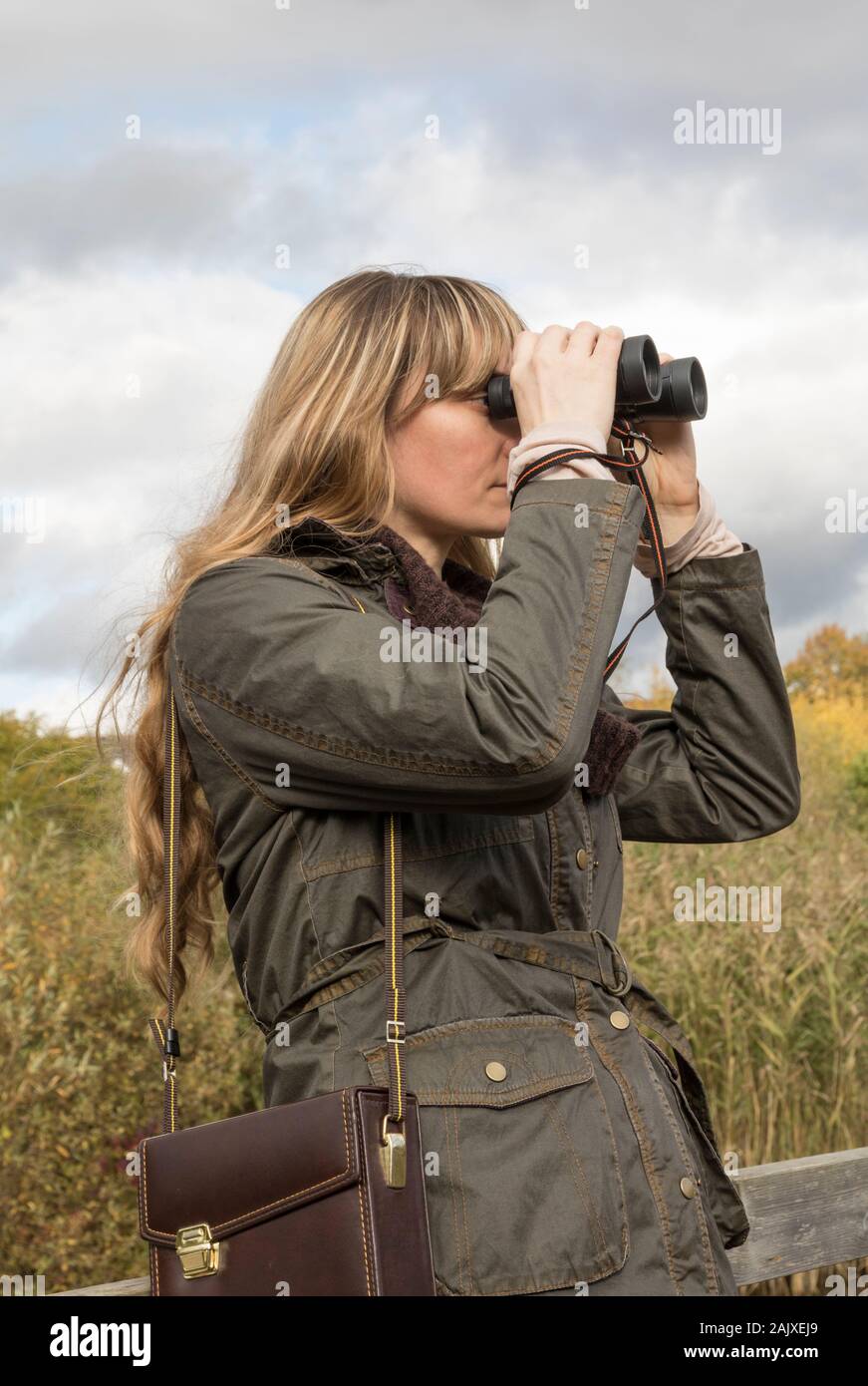 Lady bird watching using binoculars Stock Photo Alamy
