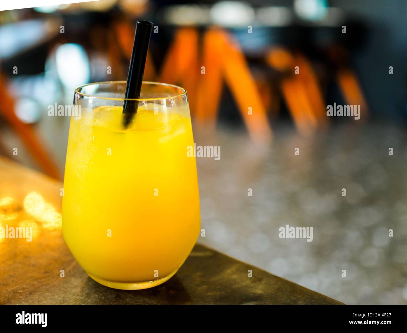 Glass of orange juice / fruit juice in a bar / pub setting with copy space. Illustrative of a teetotal healthy lifestyle Stock Photo