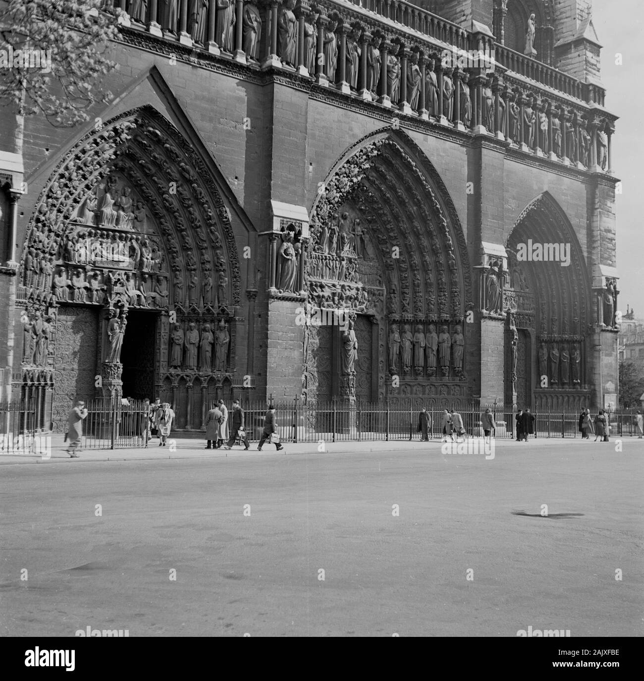 1950s, historical, a view from this era of the grand entrance to the famous french landmark, the medieval Notre-Dame Cathedral, Paris, France, considered to be one of the finest examples of French Gothic architecture. Stock Photo