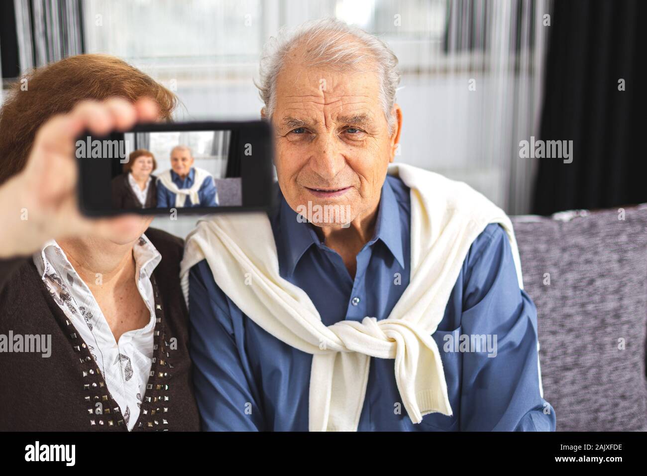 Senior couple makes selfie using a smartphone at home Stock Photo